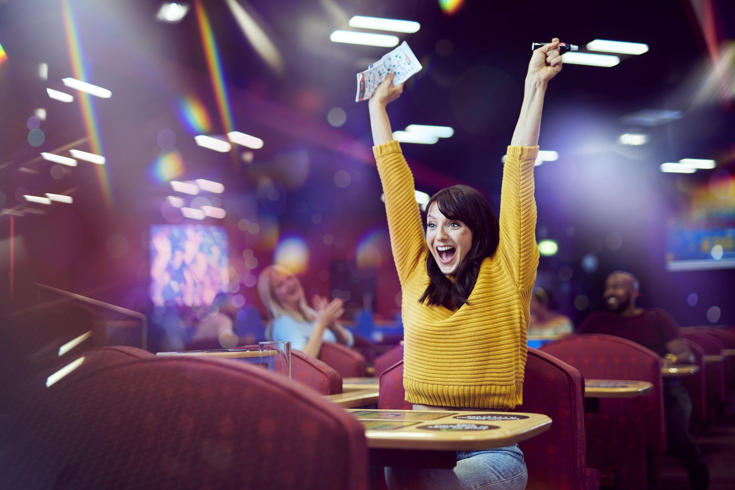 Buzz Bingo woman shouting with hands in air as she wins