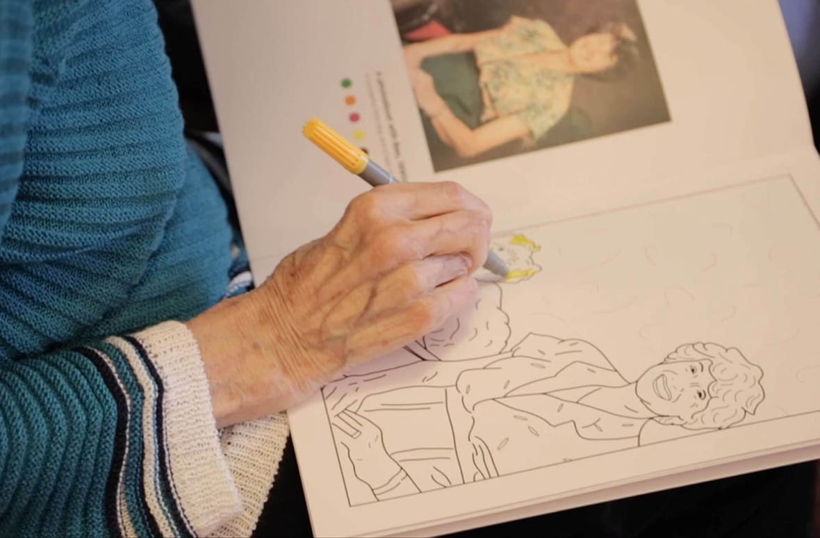 Picture of elderly person colouring a picture from one of the colourful life colouring books.