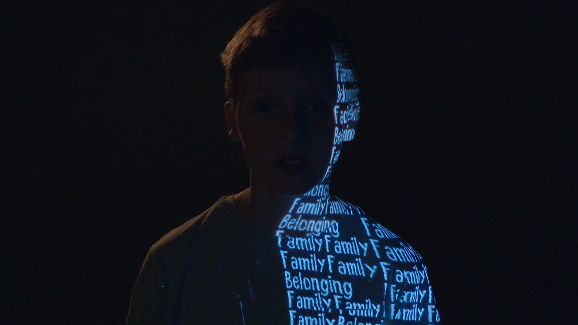 Young boy with the words Family and Belonging projected down one side of his body.